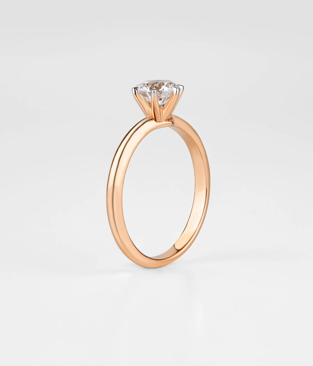 Round solitaire diamond engagement ring on a white backdrop