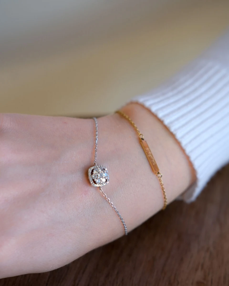 Halo diamond bracelet on a fine chain worn on the wrist