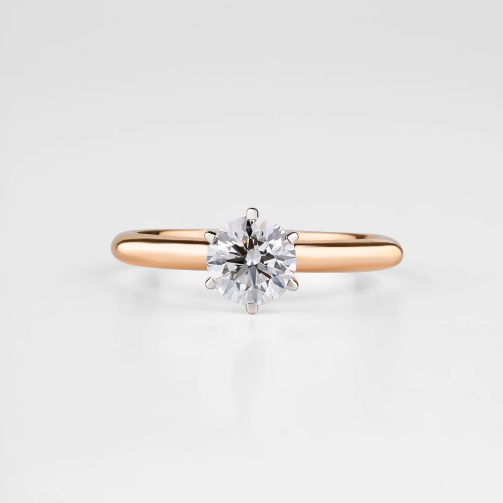 Round solitaire diamond engagement ring on a plain white background