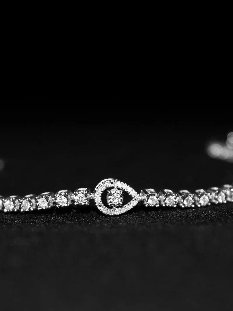 White-gold diamond tennis bracelet with a pear halo center on black