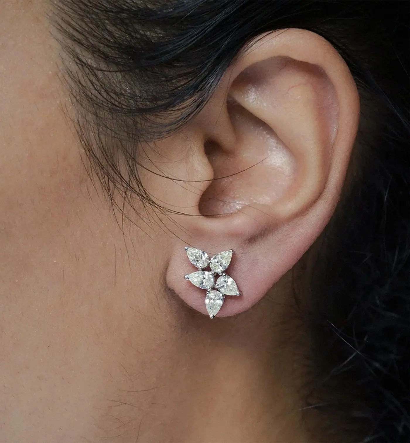 Ear wearing a pear-shaped diamond cluster stud earring