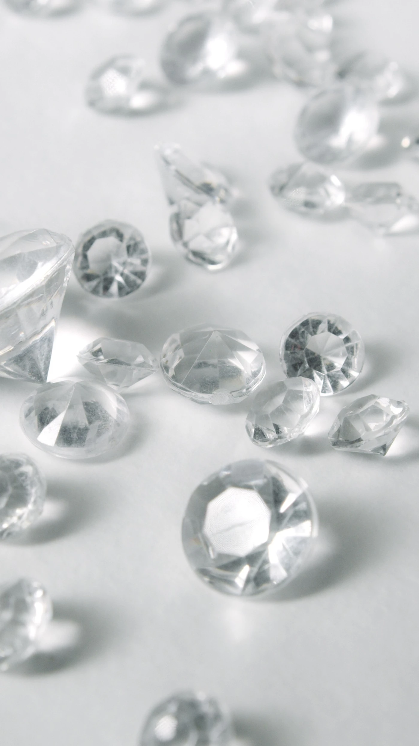 Loose round and fancy-cut diamonds scattered on a white surface