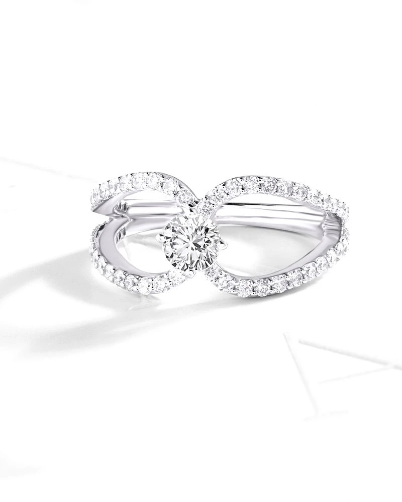 White-gold diamond engagement ring with a split pavé band on a plain white background