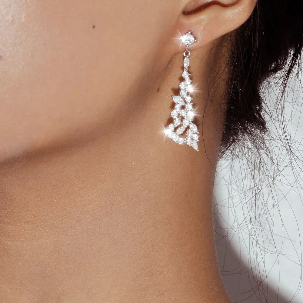 Diamond drop earring worn in a light natural close-up