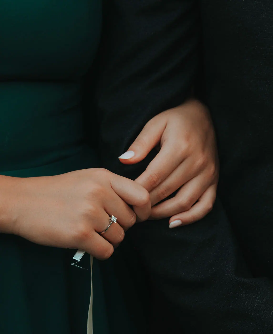 Hands wearing a diamond engagement ring
